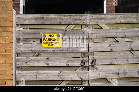 Kein Parkplatz, halten Sie die Einfahrt frei auf einem inoffiziellen Schild an einem Tor zu einer privaten Einfahrt in Großbritannien. Stockfoto