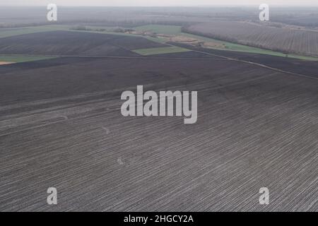 Luftdrohne Aufnahme von landwirtschaftlichen Grundstücken für die Landwirtschaft. Agrarland für die Agrarindustrie. Topographische Aufnahme des Winterfeldes. Leeres Feld ist Ackerland: Drohnenansicht. Stockfoto