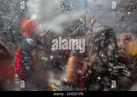 Jungen und Mädchen nehmen an einer Party mit Wasser auf den Straßen Teil Stockfoto