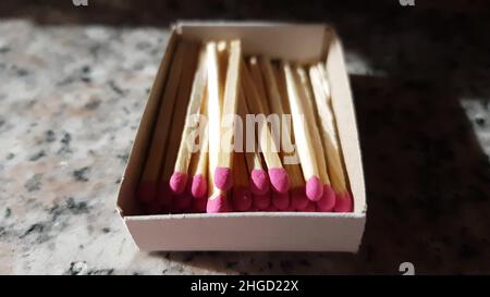 Pappkarton mit rosa Streichhölzern auf einem Granittisch Stockfoto