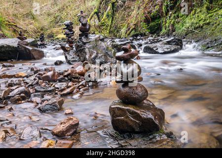 Steinstapel oder Felsausgleich am Fluss. Zen ausgewogene Kieselsteine Stapel Kunst. Schöne ruhige idyllische Landschaft Hintergrund mit langer Belichtung. Entspannung, Umwelt und Ökosystemkonzept. Stockfoto