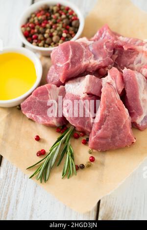 Rohes Schweinefleisch auf Holztisch in Stücke geschnitten Stockfoto