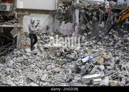 Arbeiter arbeiten daran, die Schutt zu entfernen das zerstörte Gebäude wurde durch Luftangriffe während des israelisch-palästinensischen Konflikts im vergangenen Jahr im Gazastreifen am 19. Januar 2022 zerstört. Stockfoto