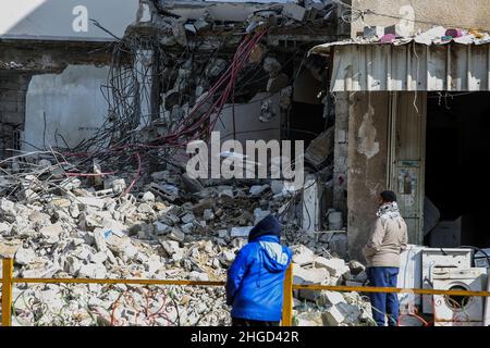 Arbeiter arbeiten daran, die Schutt zu entfernen das zerstörte Gebäude wurde durch Luftangriffe während des israelisch-palästinensischen Konflikts im vergangenen Jahr im Gazastreifen am 19. Januar 2022 zerstört. Stockfoto