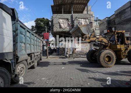 Arbeiter arbeiten daran, die Schutt zu entfernen das zerstörte Gebäude wurde durch Luftangriffe während des israelisch-palästinensischen Konflikts im vergangenen Jahr im Gazastreifen am 19. Januar 2022 zerstört. Stockfoto