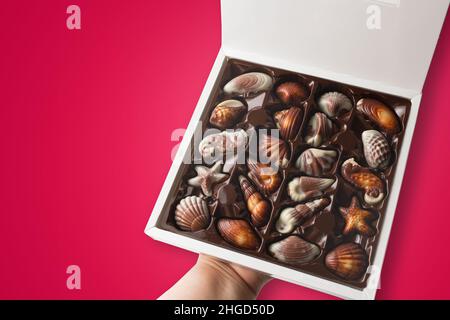 Schachtel Pralinen auf rotem Hintergrund. Stockfoto