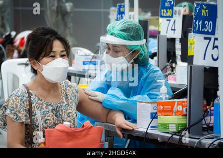 Bangkok, Thailand - Febuary 9, 2022 : Asian Arzt oder Krankenschwester, die covid Antivirus-Impfstoff Booster Dosis an ältere Frau Patient tragen schützende f Stockfoto