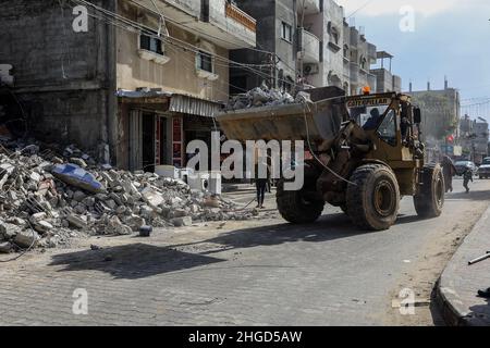 Arbeiter arbeiten daran, die Schutt zu entfernen das zerstörte Gebäude wurde durch Luftangriffe während des israelisch-palästinensischen Konflikts im vergangenen Jahr im Gazastreifen am 19. Januar 2022 zerstört. Stockfoto