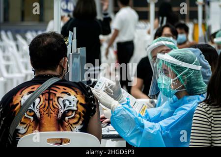 Bangkok, Thailand - Februar 4, 2021 : Asian doctor giving omicron covid Antivirus Vaccine Booster Dose to man Patient wearing protective face mask f Stockfoto