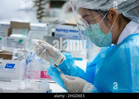 Bangkok, Thailand - 25. Januar 2022 : Arzt nimmt Coronavirus-Impfstoff in Spritze zur Injektion von omicron covid Booster-Impfung. Stockfoto