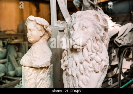 Handgemeißelte Statue eines Löwen in einer Marmorwerkstatt in Italien, die in einem Bergbau- und Produktionskonzept aus weißem Stein gemeißelt wurde Stockfoto