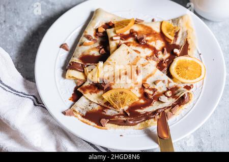 Crepes Pfannkuchen in Pyramidenform auf einem blauen Teller in hellem Hintergrund gebildet Stockfoto