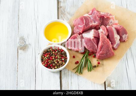 Rohes Schweinefleisch auf Holztisch in Stücke geschnitten Stockfoto