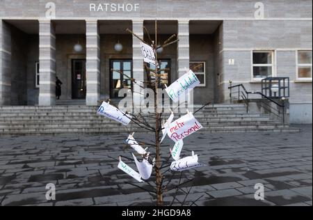 29. Dezember 2021, Sachsen-Anhalt, Halle (Saale): Ein abgebrannter Weihnachtsbaum mit Forderungen an die Stadt steht vor dem gemeinderat. Feuerwehrleute nutzen sie, um gegen „geheime Kostensenkungsmaßnahmen“ und mangelnde Wertschätzung der Stadt zu protestieren. Foto: Kevin Meyer/dpa-Zentralbild/dpa Stockfoto