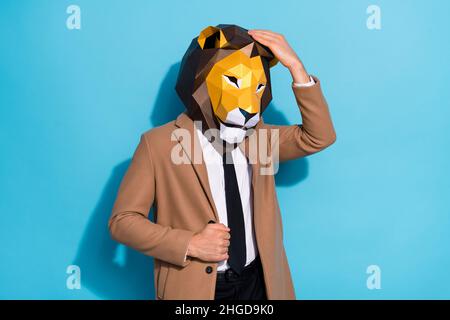 Foto von coolen kreativen Kerl berühren Hand Löwe Maske Thema festliche Anlass Vorbereitung isoliert über blauen Hintergrund Stockfoto
