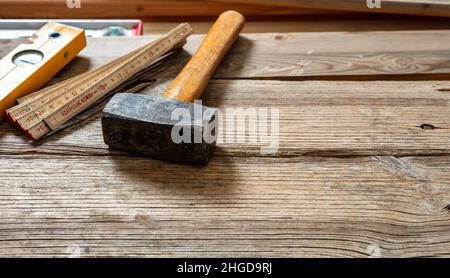 Vorschlaghammer alt mit Holzgriff auf Holz verwendet, kopieren Raum. Bauindustrie, Tischler Arbeitstisch mit Vintage-Werkzeug Stockfoto