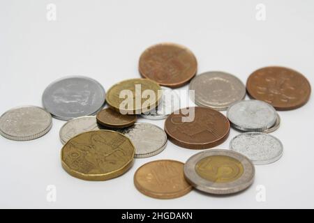 Münzen verschiedener Länder. Eine Streuung von Münzen auf weißem Hintergrund. Geringe Schärfentiefe Stockfoto