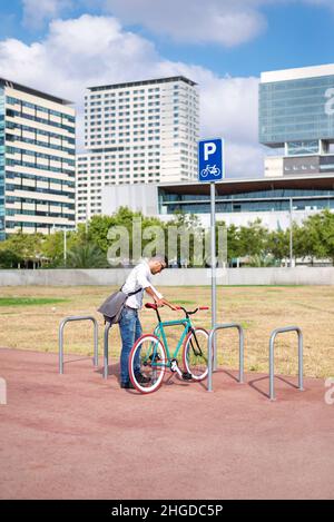 Business, Lifestyle, Verkehr und Menschen Konzept - junge Mann Parkplatz Fahrradverleih am Ort Straße Stockfoto