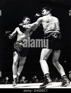 Der Schwergewichtsmeister Joe Louis liefert Abe Simon auf dem Weg zum K.o.-Sieg in der 6. Runde mit einer harten Linken an den Kiefer. Im Madison Square Garden in New York, 27. März 1943 Stockfoto