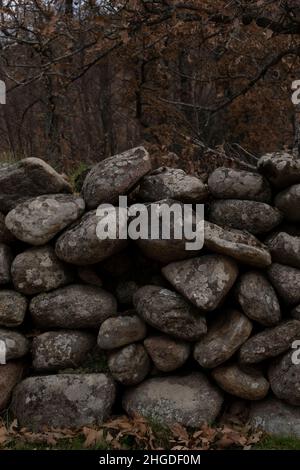 Eine kleine Wand aus Felsen markiert eine Grundstückslinie. Navamediana. Naturpark Sierra de Gredos. Provinz Ávila. Spanien Stockfoto