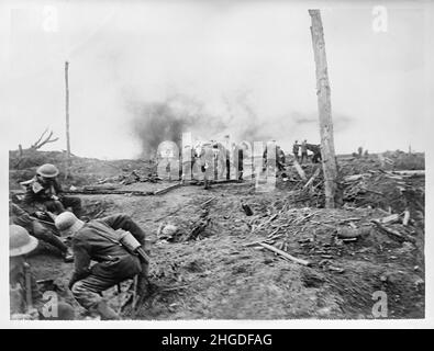 Ein Vintage-Foto von deutschen und britischen Soldaten, die verwundete Männer an der Westfront unter Beschuss von Panzern um 1918 evakuierten. Stockfoto