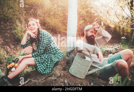 Paar auf dem Bauernhof auf dem Land Hintergrund. Glückliches Paar Bauern, die mit Spud auf dem Frühlingsfeld arbeiten. Frau und Mann verbringen Zeit im Obstgarten. Stockfoto