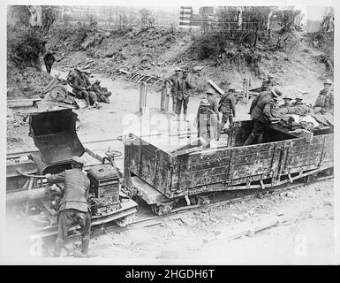 Ein Vintage-Foto von britischen Soldaten, die verwundete Männer mit einem benzinbetriebenen Simplex 20hp Traktormotor und leichten Eisenbahnwaggons an der Westfront in Arras um den 29th. April 1917 evakuieren. Angetrieben von 20hp Dorman 2JO Benzinmotoren wurden Simplex-Loks für die Lieferung von Munitionsmaterial und Lagerhäusern, den Transport von Truppen und die Evakuierung der Verwundeten eingesetzt Stockfoto