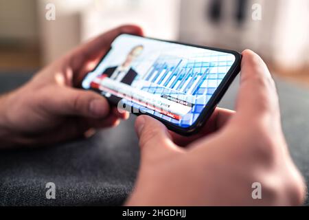 Nachrichten im Telefon aus dem tv-Broadcast-Stream. Mann, der die neuesten täglichen Informationen aus dem Streaming von Live-Videos mit dem Smartphone ansieht. Schlagzeile. Stockfoto