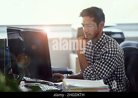 Durchdenken. Eine kurze Aufnahme eines Geschäftsmanns, der an seinem Schreibtisch arbeitet. Stockfoto