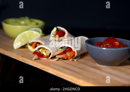 Leckeres veganes Mittagessen, gegrillte Gemüsepackungen mit Guacamole und Tomatensalsa Stockfoto