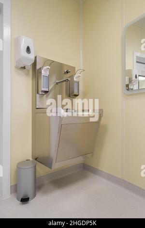 Ellenbogen Seife und antiseptischen Spender oder Desinfektionsmittel Wand zur Händedesinfektion und Wasserhahn Waschbecken mit Wasserhahn Bad oder Klinik montiert Stockfoto