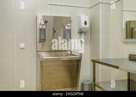 Ellenbogen Seife und antiseptischen Spender oder Desinfektionsmittel Wand zur Händedesinfektion und Wasserhahn Waschbecken mit Wasserhahn Bad oder Klinik montiert Stockfoto