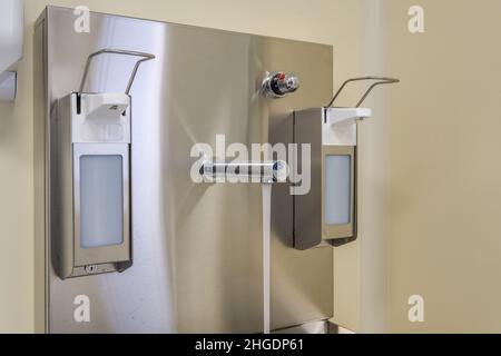 Ellenbogen Seife und antiseptischen Spender oder Desinfektionsmittel Wand zur Händedesinfektion und Wasserhahn Waschbecken mit Wasserhahn Bad oder Klinik montiert Stockfoto