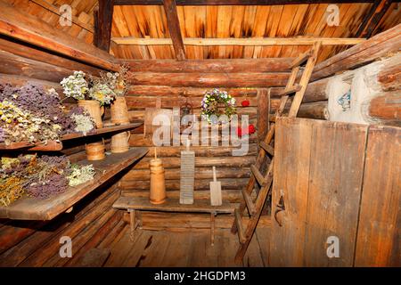 Der Hauswirtschaftsraum und die Eingangshalle einer alten ländlichen Hütte sind mit verschiedenen Haushaltsgeräten aus Holz gefüllt. Stockfoto