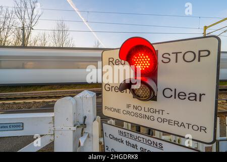 Der Zug fährt über eine Light Controlled Level und überquert die Haupteisenbahn nach Norfolk in Margareting Essex Stockfoto