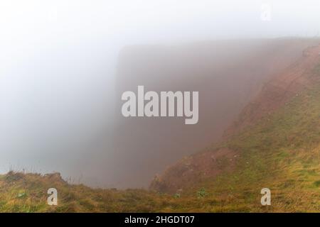 Rote Sandsteinklippen im dichten Nebel auf dem Hochseesland Helgoland, Nordsee, Norddeutschland, Mitteleuropa Stockfoto