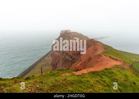 Rote Sandsteinklippen im dichten Nebel auf dem Hochseesland Helgoland, Nordsee, Norddeutschland, Mitteleuropa Stockfoto