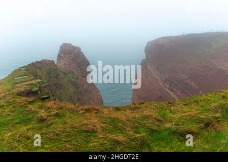 Rote Sandsteinklippen im dichten Nebel auf dem Hochseesland Helgoland, Nordsee, Norddeutschland, Mitteleuropa Stockfoto