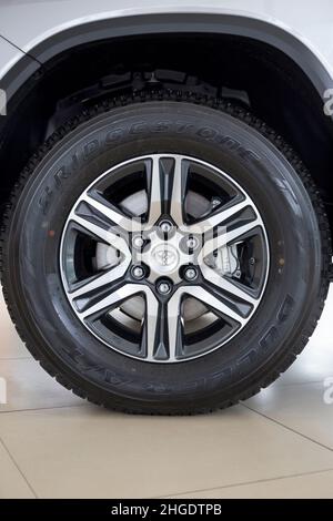 Russland, Izhevsk - 30. September 2021: Toyota Showroom. Das Rad des Fortuner Geländewagens. Leichtmetallfelge und Bridgestone-Reifen. Berühmte Weltmarke. Stockfoto