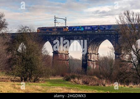 Die elektrische Diesellokomotive der Baureihe 60 fährt den Biomasse-Zug Drax vom Dock in Liverpool über das Sankey Valley Viadukt in Earlestown. Stockfoto