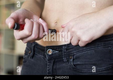 Frau, die Insulin in den Bauch spritzt Stockfoto