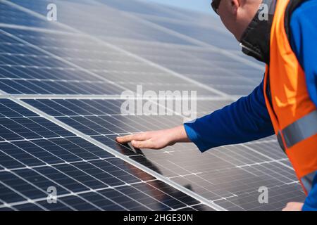 Arbeiter in Solarkraftwerken prüft die Zellen auf Schäden Stockfoto