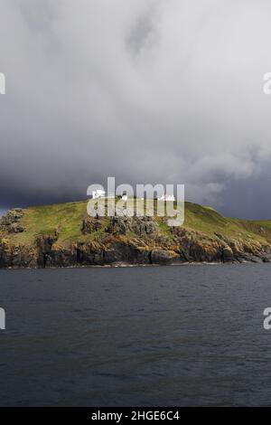 Sturmwolken sammeln sich über der National Coastwatch Institution Coastal Watch Station in Bass Point, Lizard Peninsula, Cornwall, England Stockfoto