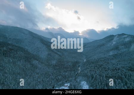 Luftaufnahme des Plateau Lago-Naki Berg verdrehte Straße im Winter und Auto fahren. Epischer, schneeweißer Winter und schneebedeckter Wald. Stockfoto