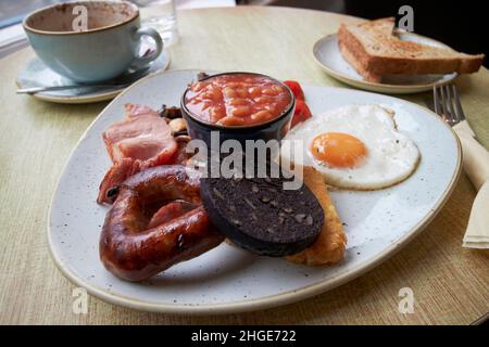 cumbrian englisches frittiertes Frühstück cumbrian Wurst, Black Pudding, Ei, Bohnen, Speck, Pilze, Hash Browns, Tomatoes Lake District, cumbria, england, Stockfoto