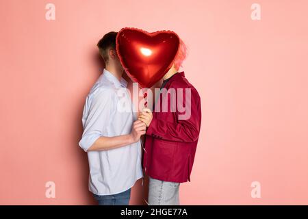 Junges Paar mit ballonförmigen Herzen. Valentinstag-Feier. Konzept der Emotionen, Gesichtsausdruck, Liebe, Beziehungen, romantische Ferien. Stockfoto