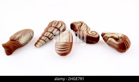 Stücke von weißer und milchfarbener Schokolade mit Nüssen und Karamellfüllung Stockfoto