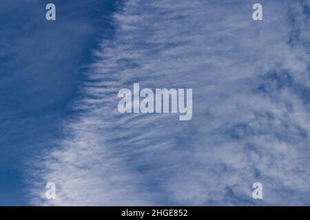 Blauer, wolkenloser Himmel. Vor dem Hintergrund des Himmels liegen weiße Streifen kondensierter Wasserdampf vom Düsenflug zurück. Stockfoto