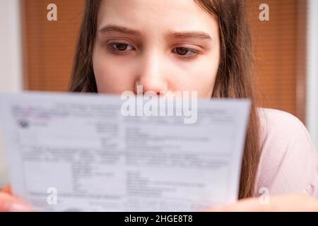 Nahaufnahme einer jungen Frau, die zu Hause besorgt und gestresst Rechnungen und Rechnungen für die Haushaltsbuchhaltung macht. Stockfoto