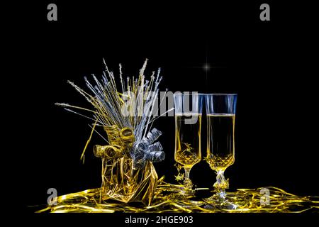 Ein Stillleben mit Champagner gefüllten Flöten mit Gold- und Silberdekor mit Kopierfläche. Stockfoto